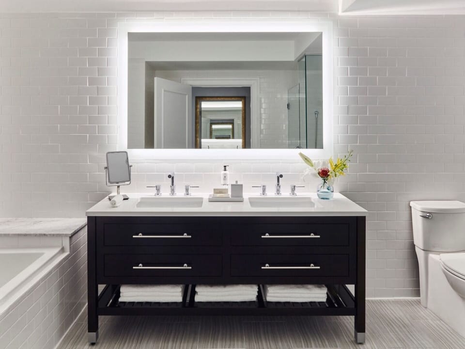 Get ready effortlessly with a double vanity and glowing mirror.