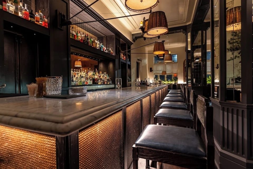 Sip craft cocktails at the sleek bar with warm golden glow.