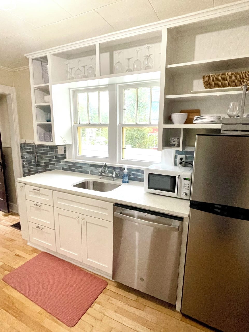 Full kitchen stocked with glassware, plates, utensils.
