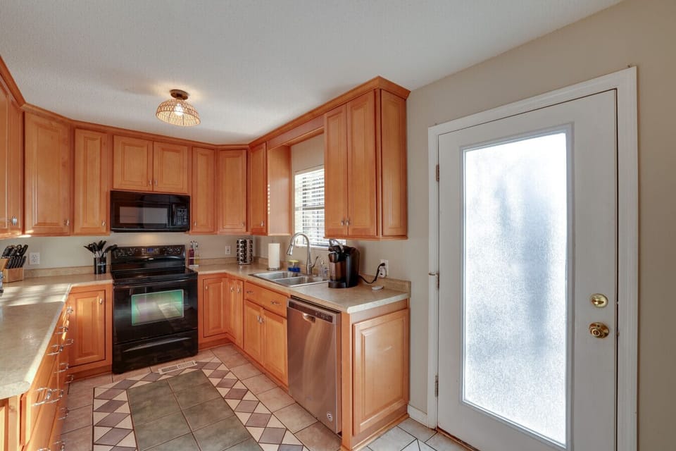A bright and spacious kitchen with a modern layout, stainless steel appliances, and outdoor access.