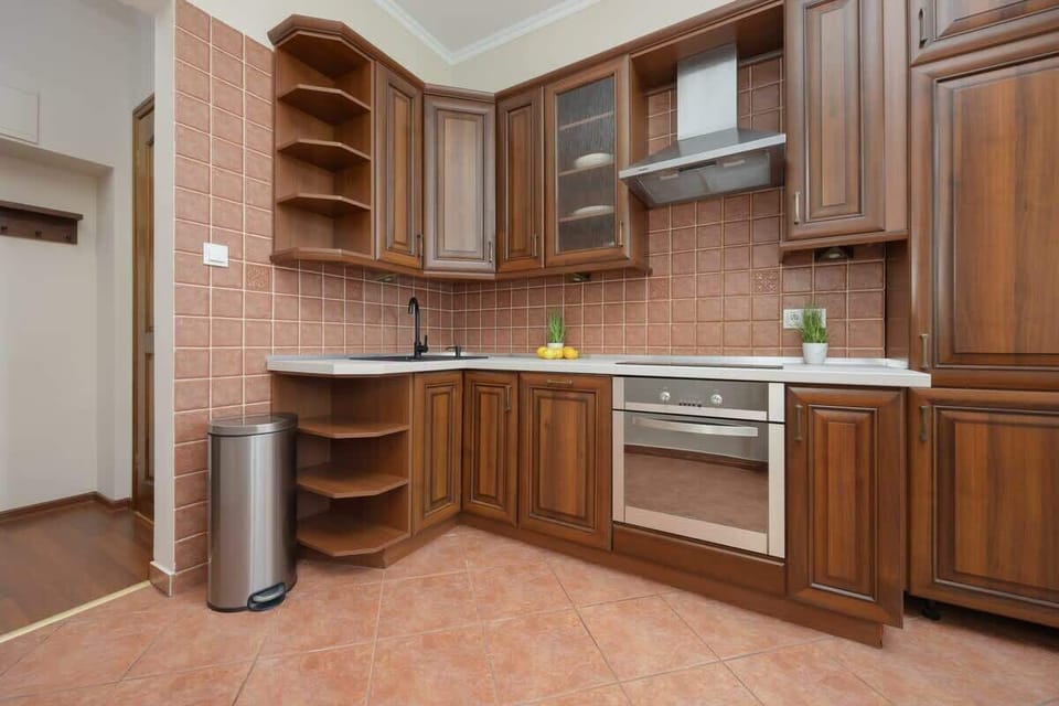 A spacious kitchen with wooden cabinets and warm-toned tiles creates a welcoming space for cooking.

