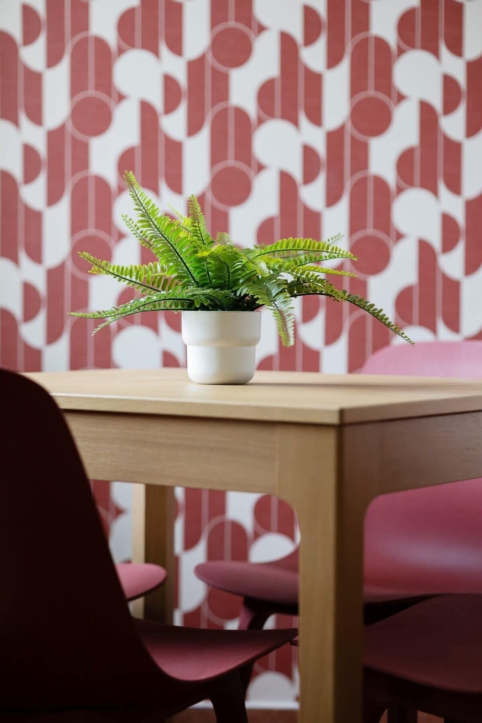 A table by the window, surrounded by patterned curtains, adds energy and a pleasant vibe to the room.