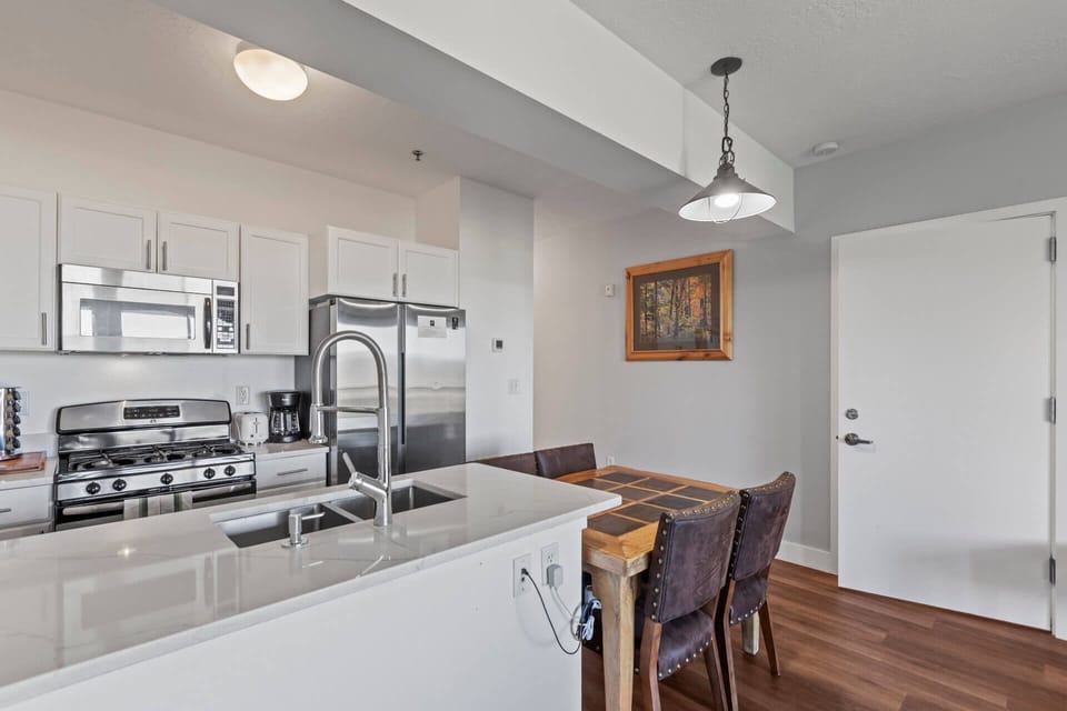 Your open-concept kitchen and dining area blends modern appliances with warm wood accents, creating an inviting space where you can cook, dine, and unwind in comfort.