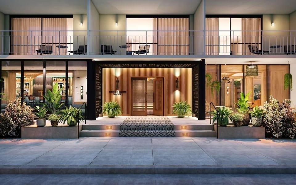 Step into a warm, design-forward entrance with lush greenery.