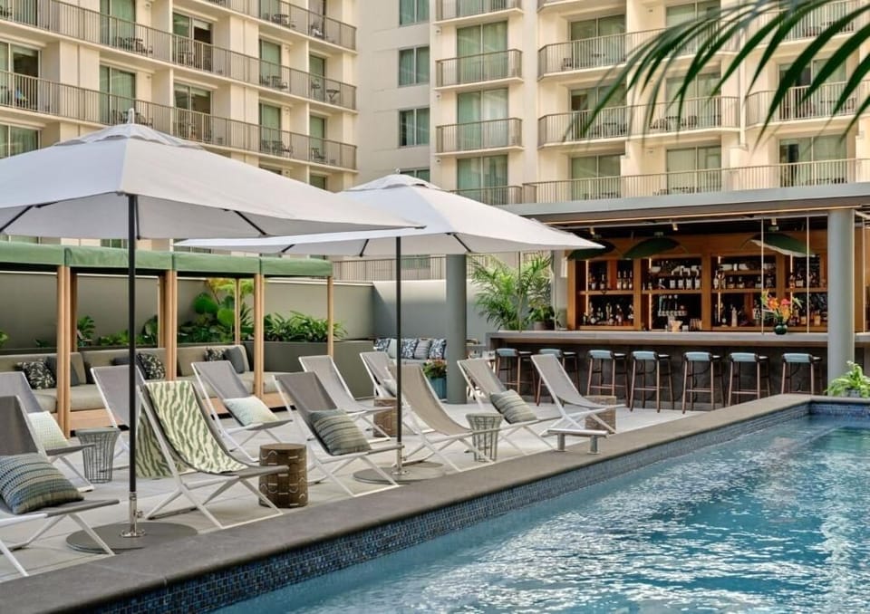Dive into a sparkling courtyard pool framed by resort balconies.