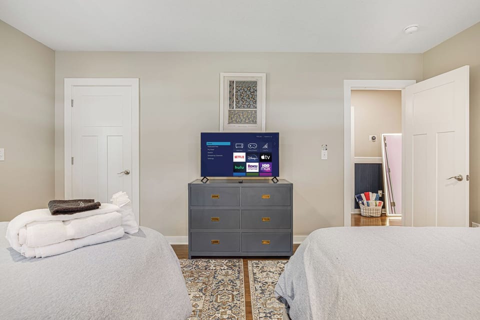TV in double queen room with dresser and a closet for space