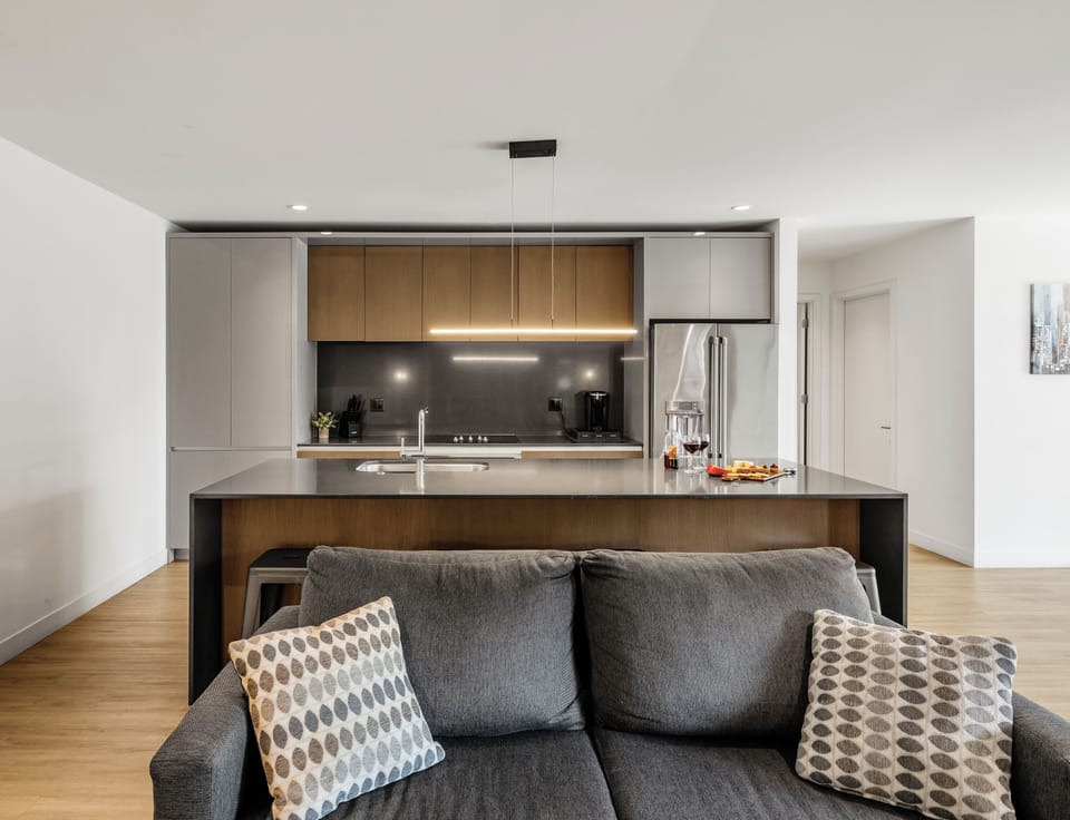 Warm and inviting living room featuring a Smart TV for entertainment, and designer furnishings including a sleeper sofa that converts into a Queen Bed.