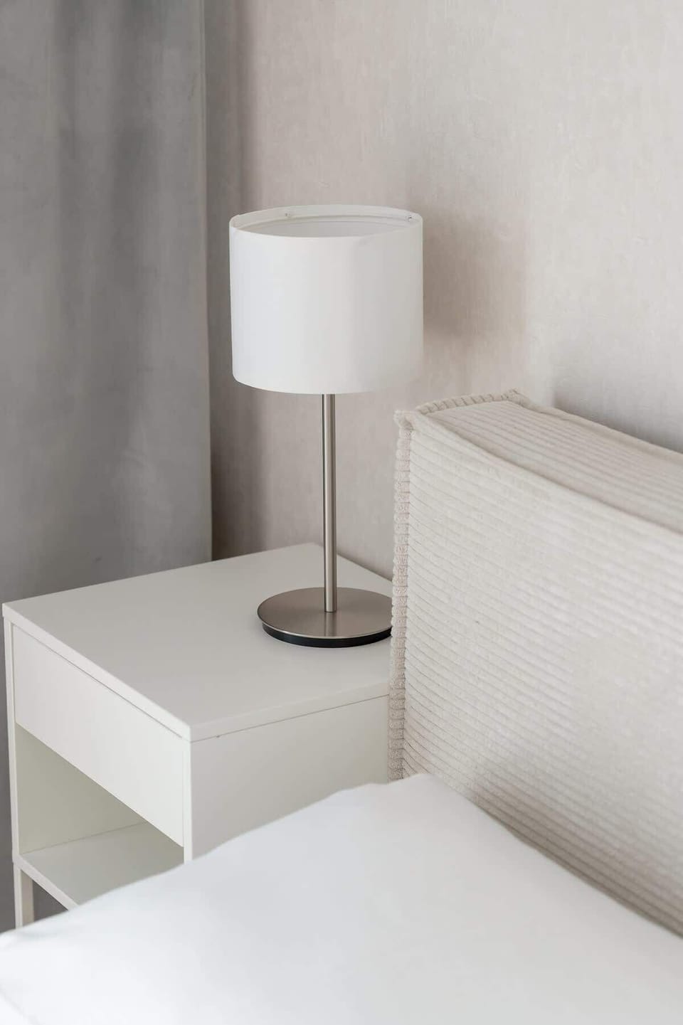 A bedside table with a lamp near the bed ensures comfort during evening reading or relaxation.
