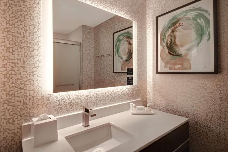Refresh at a modern vanity under flattering, spa-like lighting.