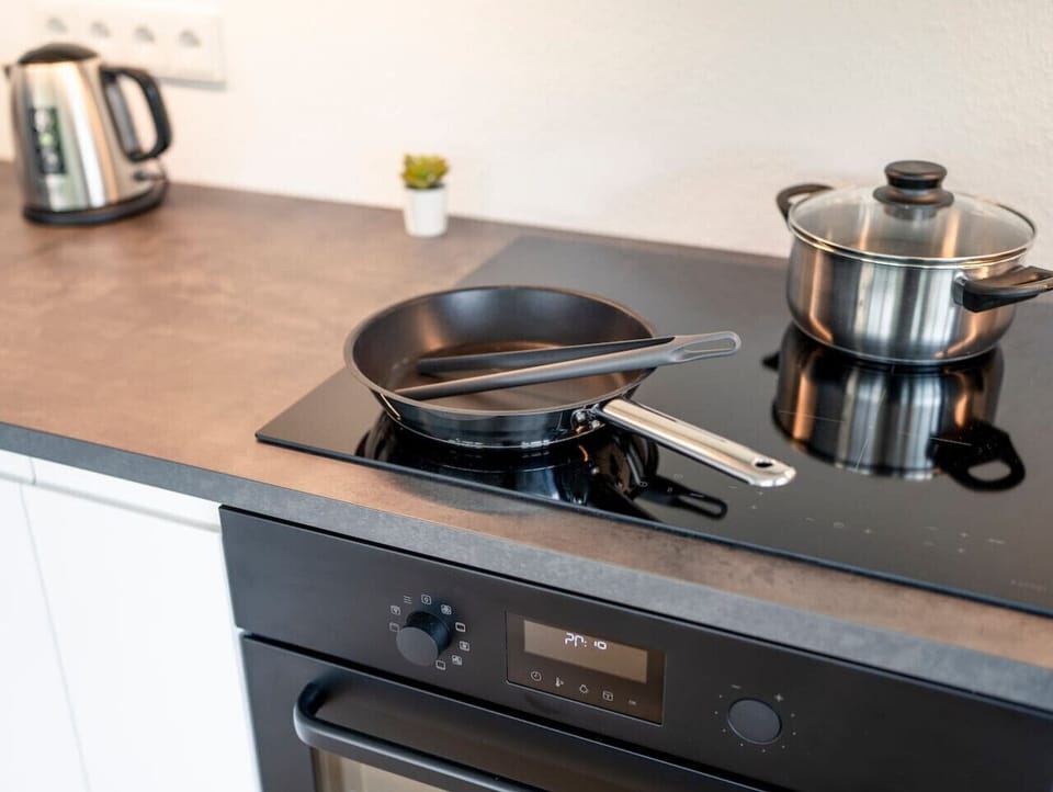 Modern ausgestattete Küche inklusive Backofen, Induktionsherd, Wasserkocher, Toaster, Spülmaschine, Kühlschrank und NESPRESSO-Kaffeemaschine, perfekt für jede Mahlzeit.
