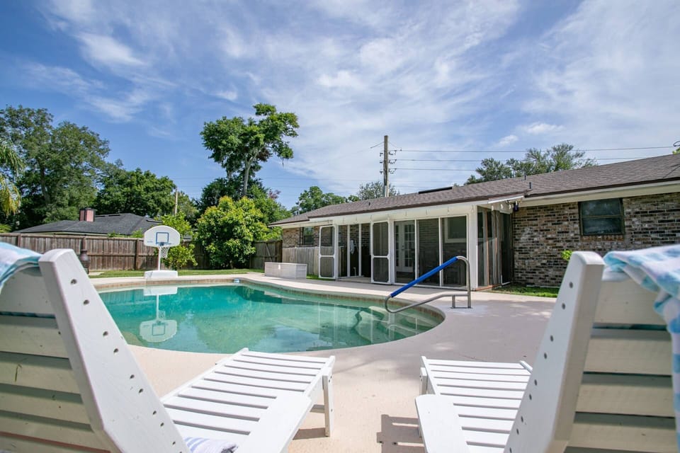 Pool lounging area looking toward screened in patio and large pool