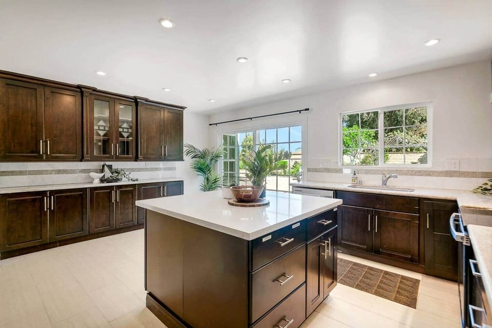 Kitchen with large island, dishwasher, sink, refrigerator, electric stove, oven