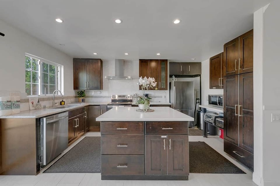 Kitchen with large island, dishwasher, sink, refrigerator, electric stove, oven