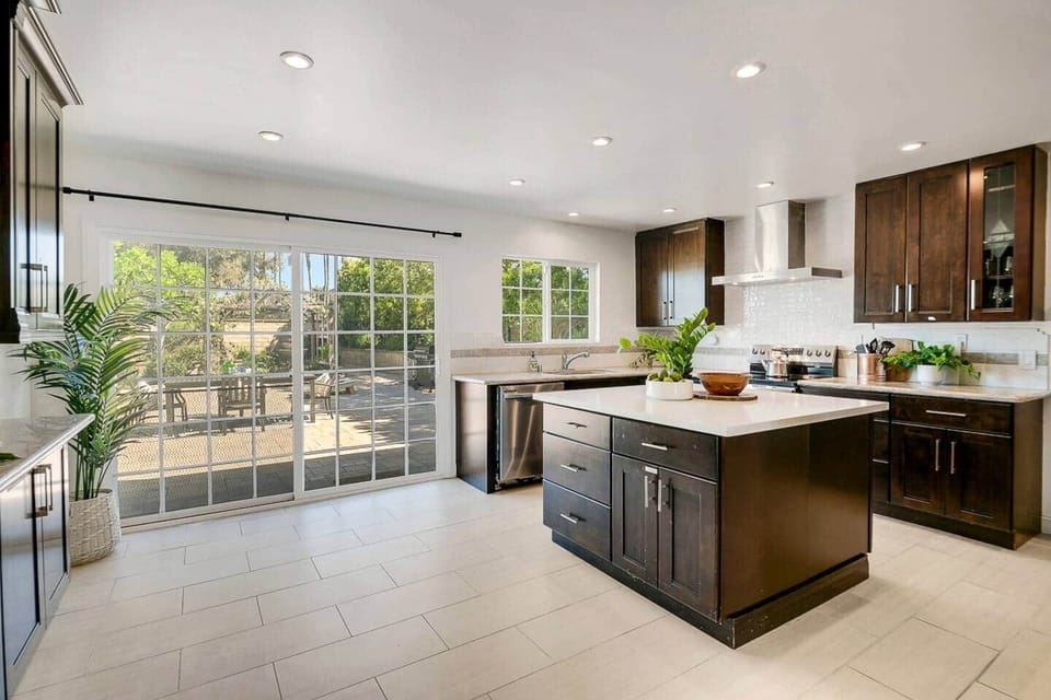 Kitchen with large island, dishwasher, sink, refrigerator, electric stove, oven