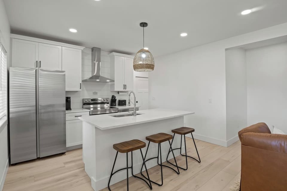 Welcome to your dream kitchen, where modern elegance meets functionality. This bright and airy space features stunning white cabinetry, sleek stainless steel appliances, and a spacious island perfect for meal prep and casual dining. Large windows flo