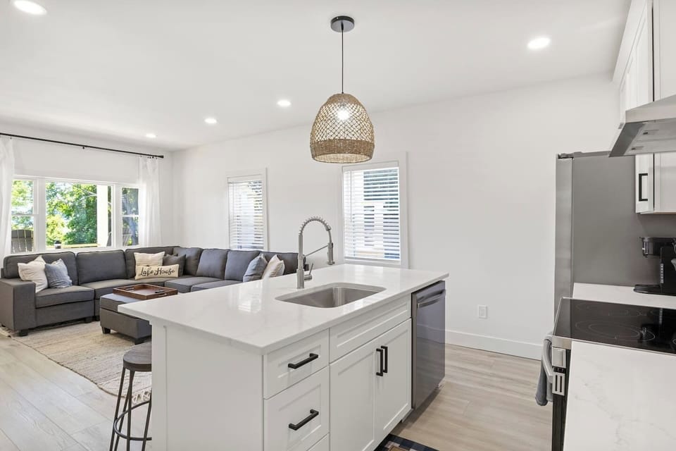 Welcome to your dream kitchen! This contemporary space is designed for both function and style, featuring a large island with bar seating and high-end appliances. The minimalist design and bright white cabinetry create an open, fresh atmosphere perfe