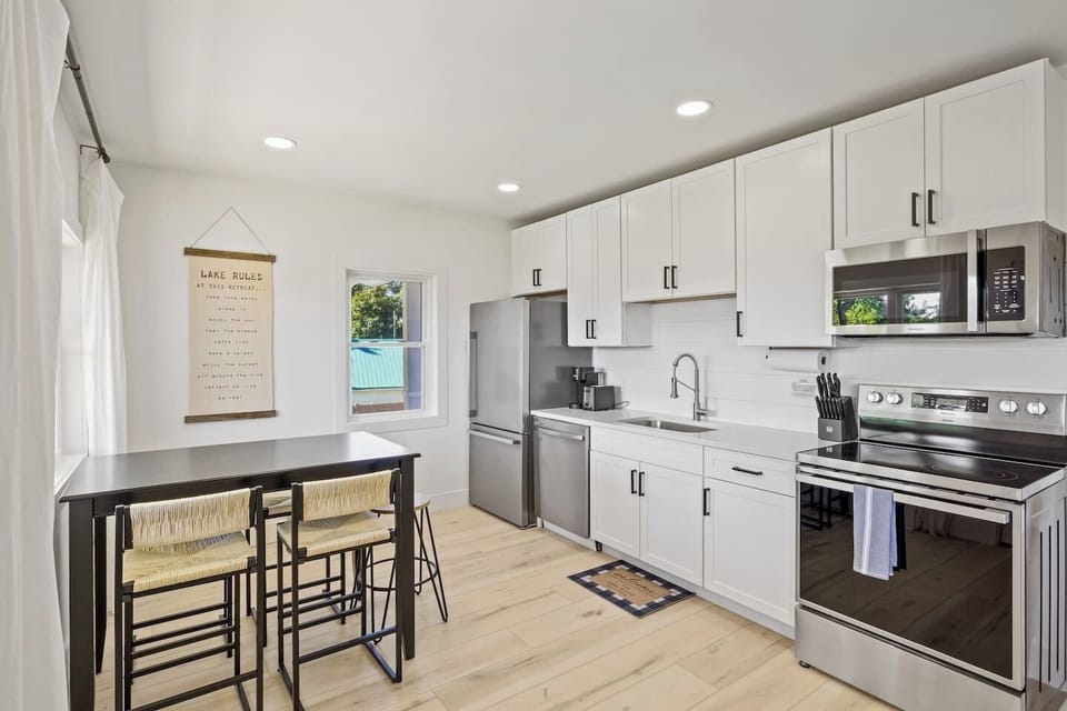 Step into this bright and modern kitchen, fully equipped with stainless steel appliances and ample counter space. The sleek design and thoughtful touches make it a joy to prepare meals and entertain guests. Enjoy casual dining at the stylish bar tabl