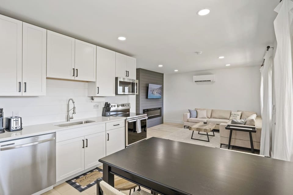 Step into this bright and modern kitchen, fully equipped with stainless steel appliances and ample counter space. The sleek design and thoughtful touches make it a joy to prepare meals and entertain guests. Enjoy casual dining at the stylish bar tabl