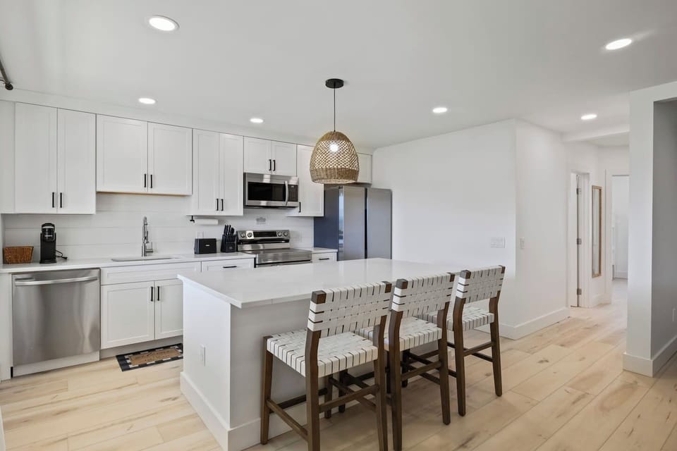This open-concept kitchen and living area offer the perfect blend of modern elegance and cozy comfort. The kitchen's island provides ample seating and counter space, ideal for entertaining or family meals. The seamless flow into the living room ensur