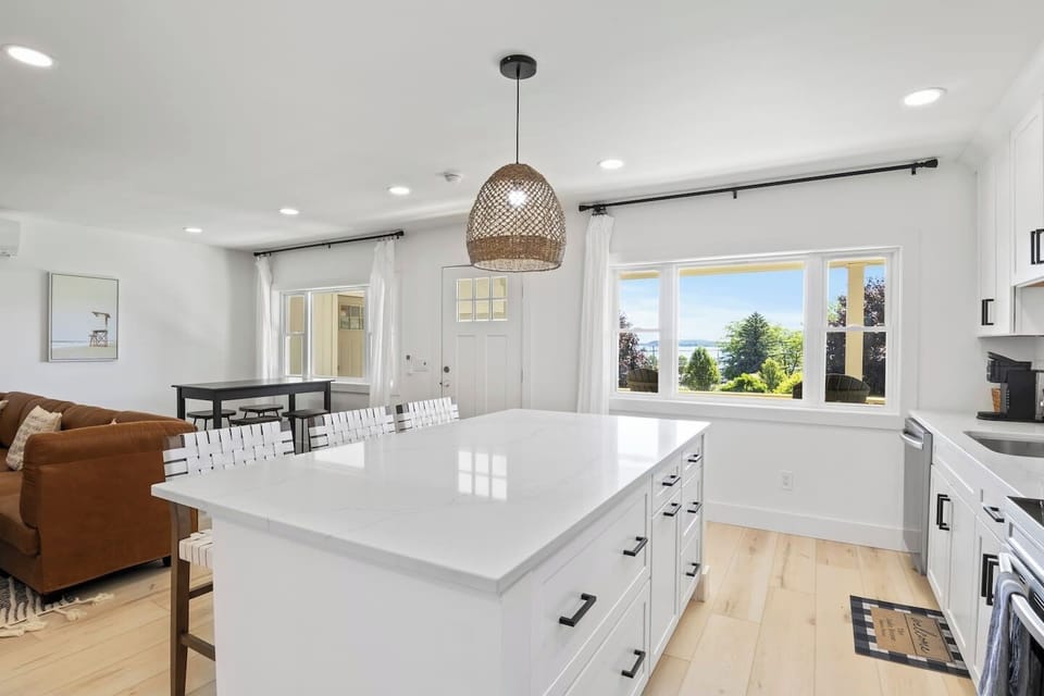 This open-concept kitchen and living area offer the perfect blend of modern elegance and cozy comfort. The kitchen's island provides ample seating and counter space, ideal for entertaining or family meals. The seamless flow into the living room ensur