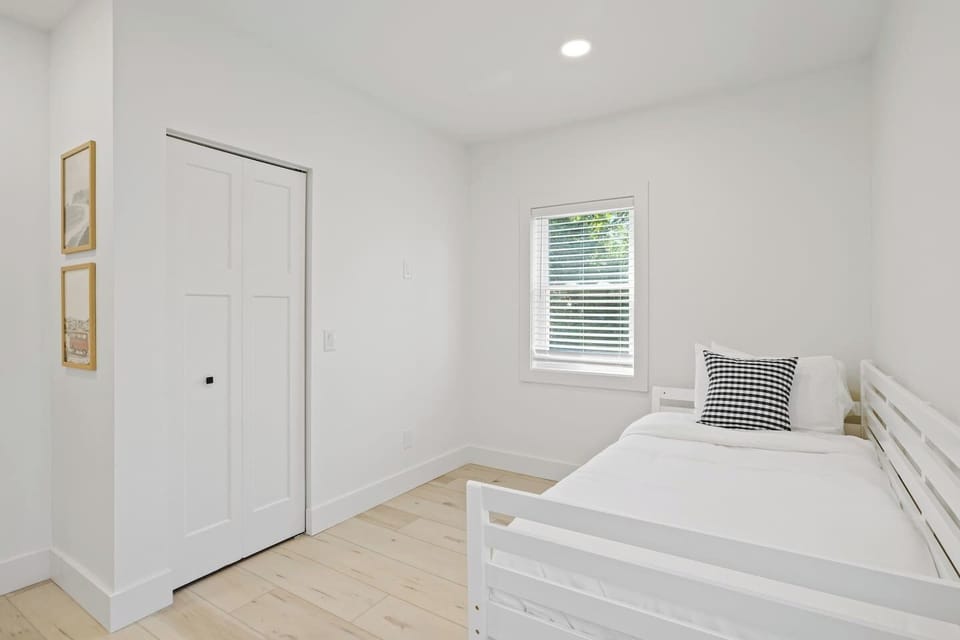 This bright and cheerful bedroom features a convenient trundle bed, perfect for accommodating extra guests or children. The minimalist design and ample natural light create a welcoming and airy space. Enjoy a restful night's sleep in this cozy and ve