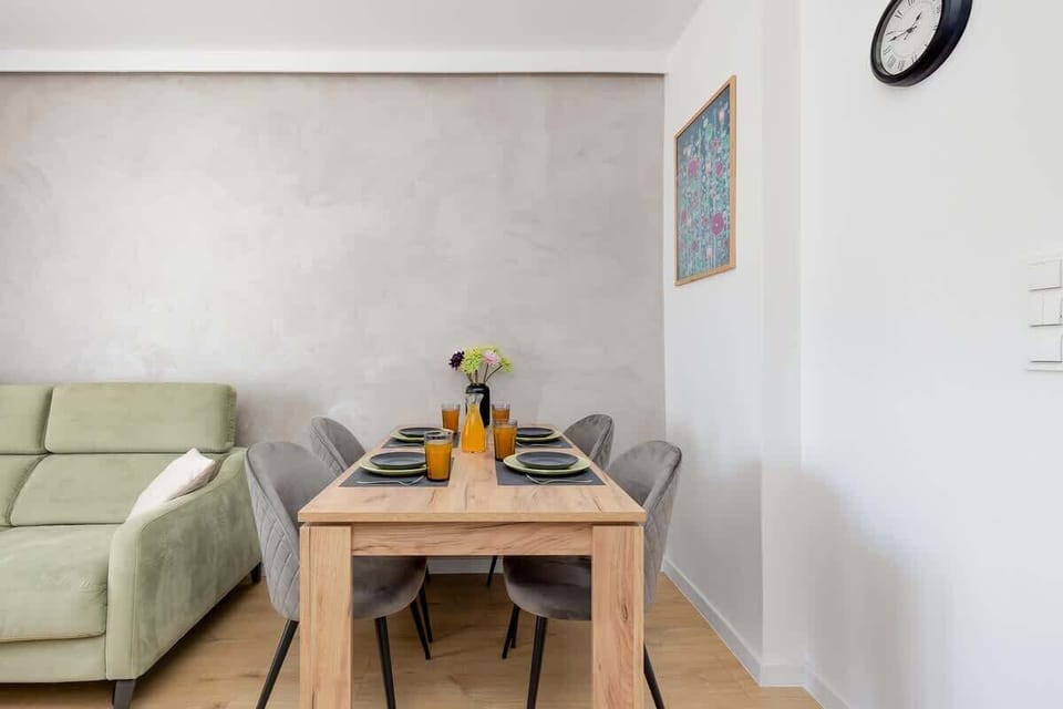A bright living room with a wooden dining table and cozy seating, ideal for shared meals.