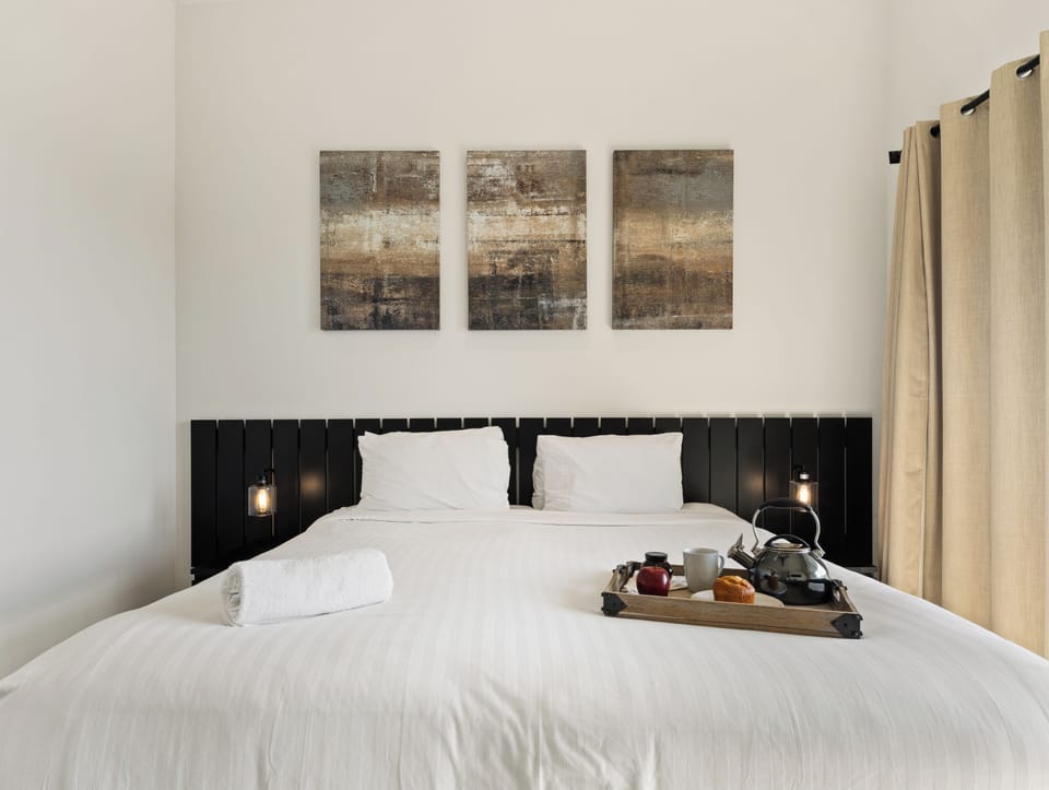 Unit 2 (1st Floor): Primary bedroom featuring a King bed, smart TV, en-suite bathroom, and a private patio.