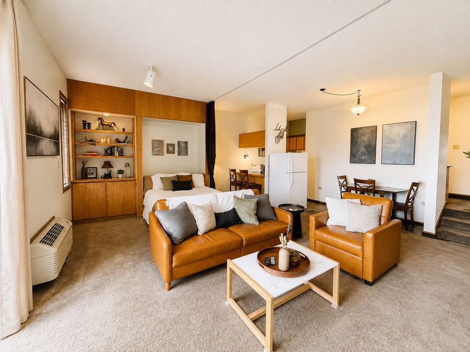 Thoughtfully designed open space that blends living, sleeping, and dining areas. Warm leather seating invites relaxation, with an integrated bed and shelving keeping everything within reach.