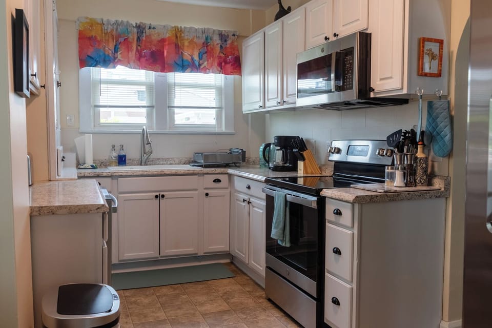 Spacious and bright kitchen offers dishwasher, stove and microwave.