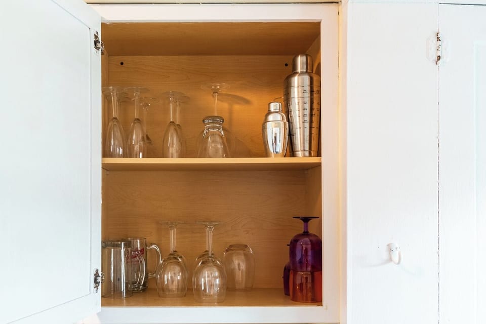 Glasses and cocktail equipment in kitchen.