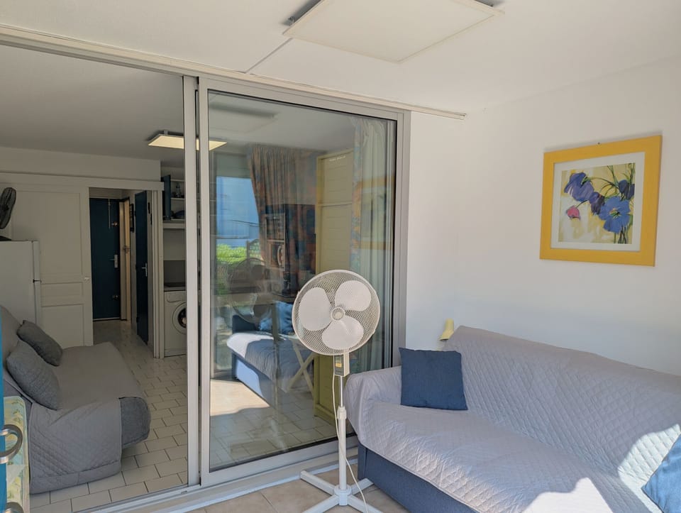 Bright closed loggia, equipped with a sofa, overlooking the living room