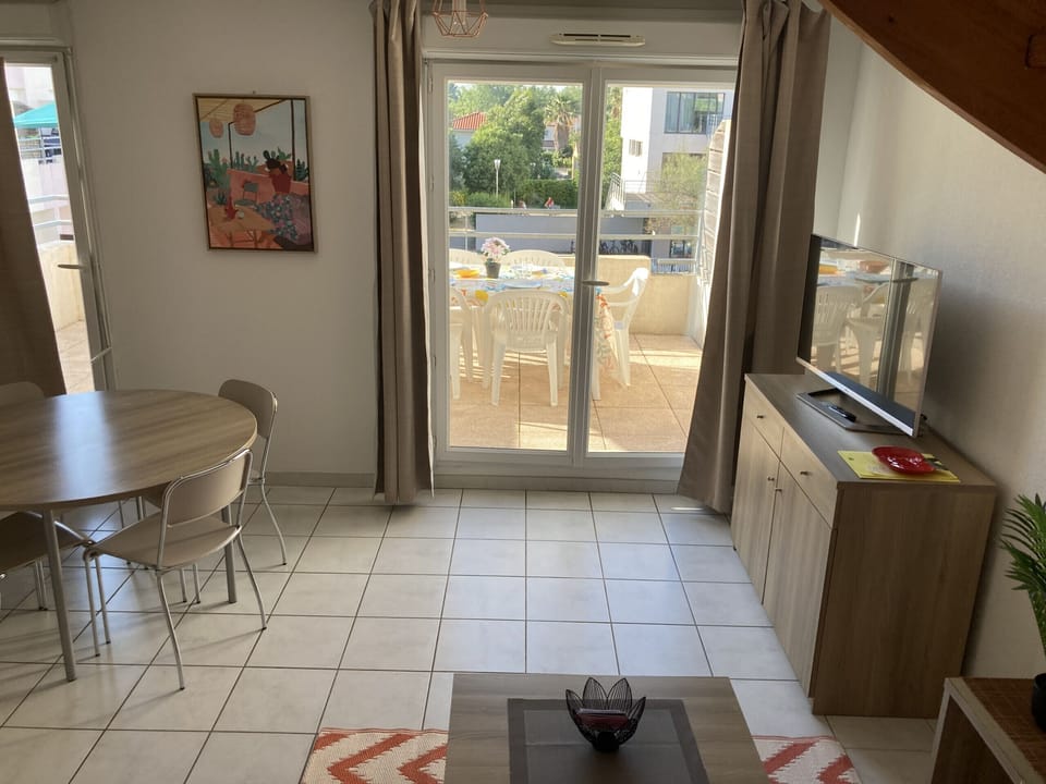 Living room with lounge and dining room overlooking the terrace