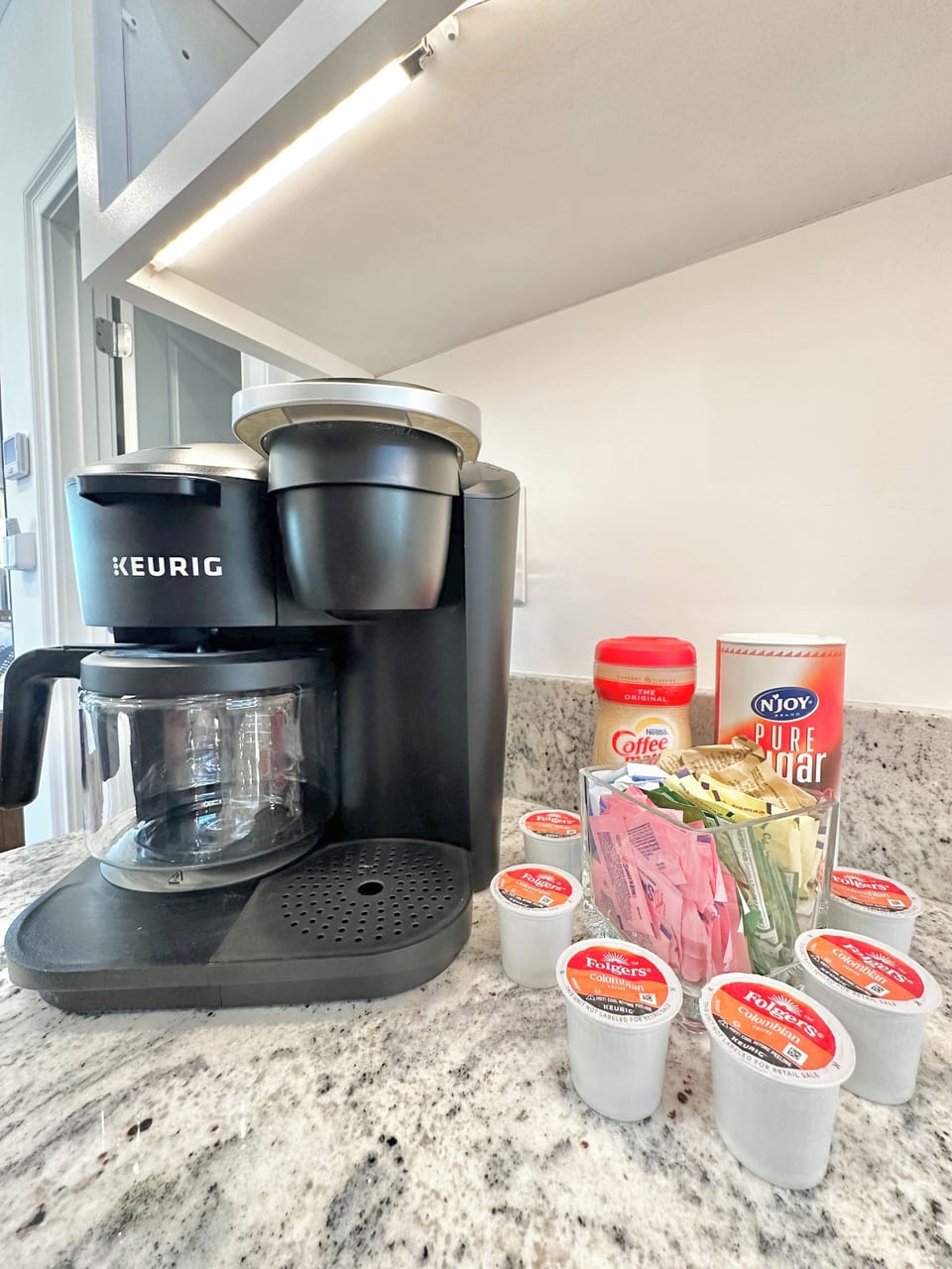 Coffee station with an assortment of sugars. There is also another K-Cup Keurig.