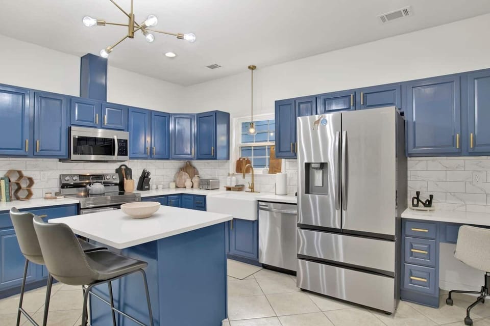 Bright kitchen with brand new stainless steel appliances, stylish "Blue Angel" themed cabinets, and fully stocked for all your cooking needs.
