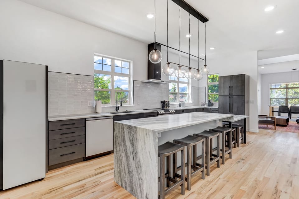 Modern kitchen features a large island, stainless steel appliances, and ample counter space, perfect for cooking and entertaining.