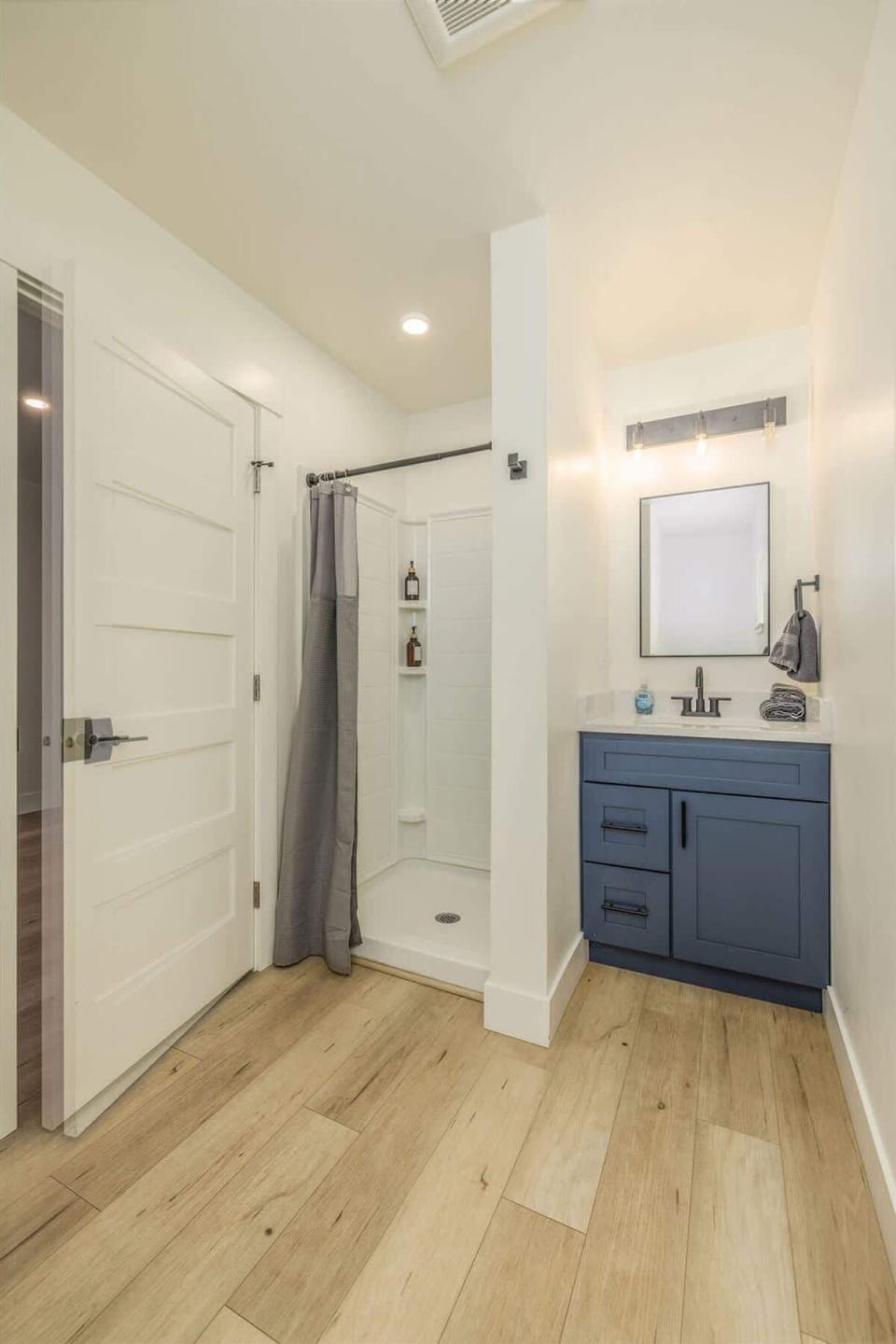 Updated bathroom with bright lighting and stall shower