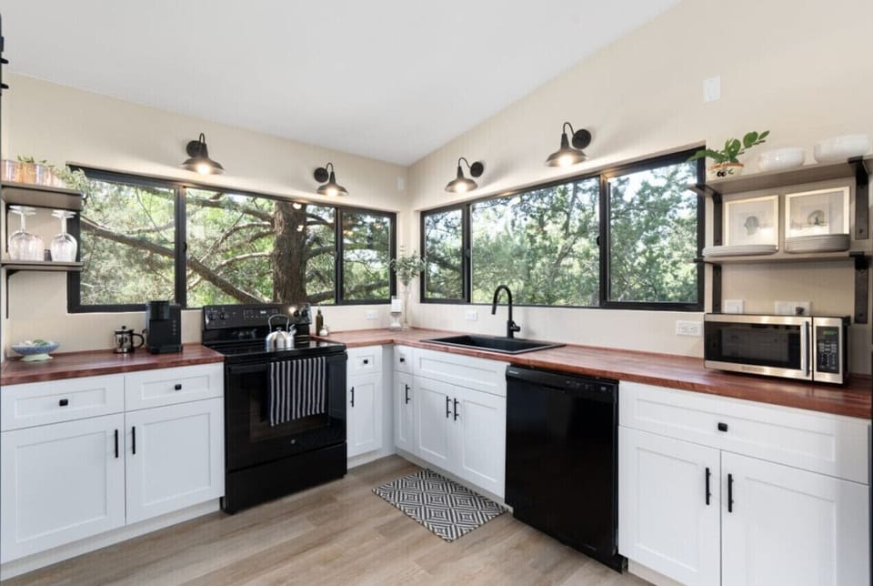 Compact kitchen with stunning nature views framed by wide, sunlit windows!