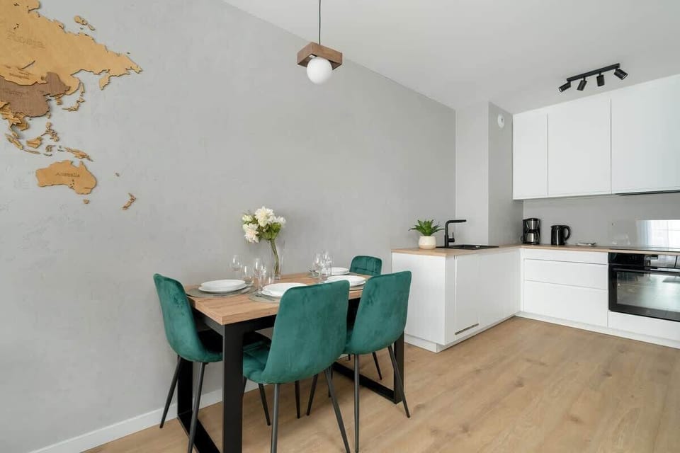 A compact kitchen in pure white tones, equipped with integrated appliances and a clean, uncluttered worktop, emphasizing simplicity and efficiency.