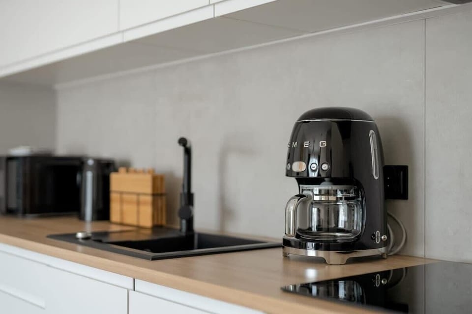 A zoomed-in shot of a kitchen counter with a coffee machine and utensils.