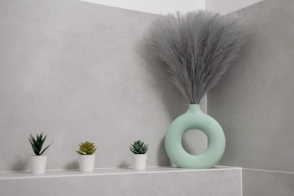 A decorative shelf with a vase, feathers, and small ornaments in pastel tones.