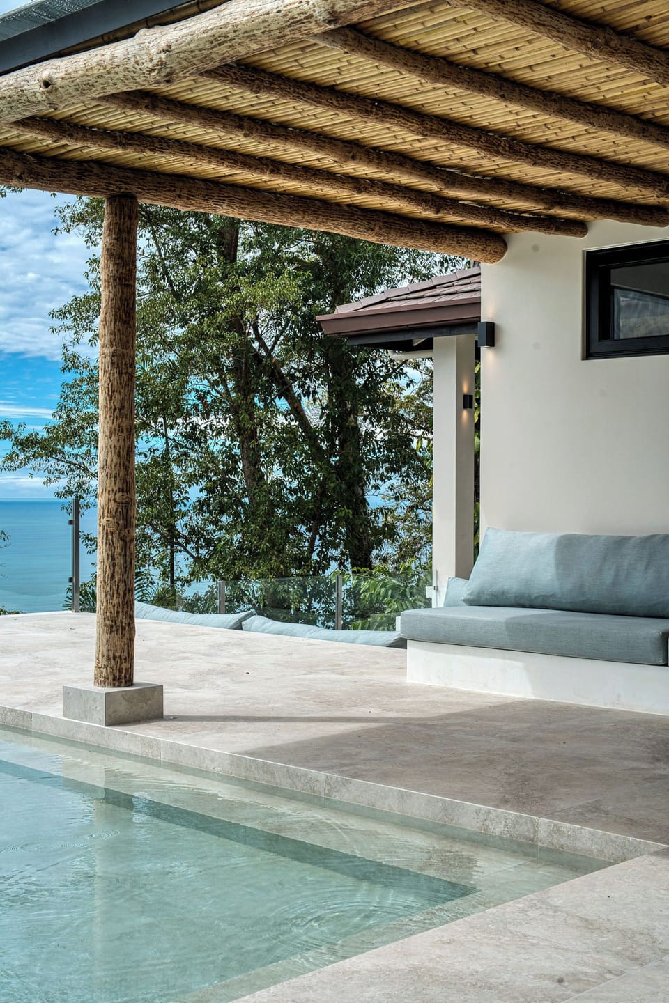 Pool lounge area, surrounded by nature and ocean views.