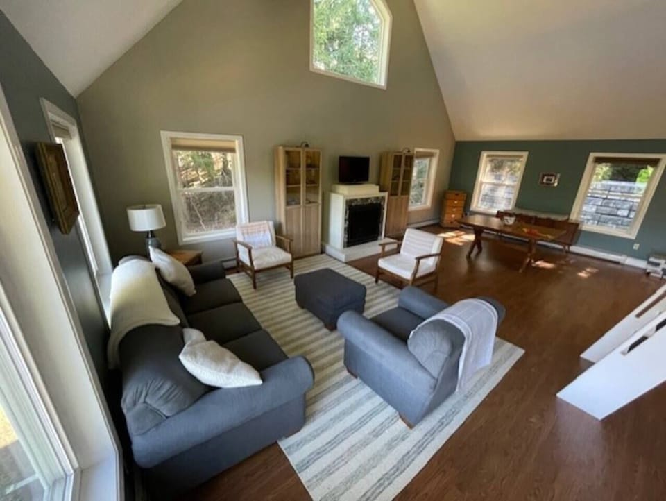 There is an open concept living room, dining room, and kitchen area with TV, dining table and access to a loft by way of ships ladder.