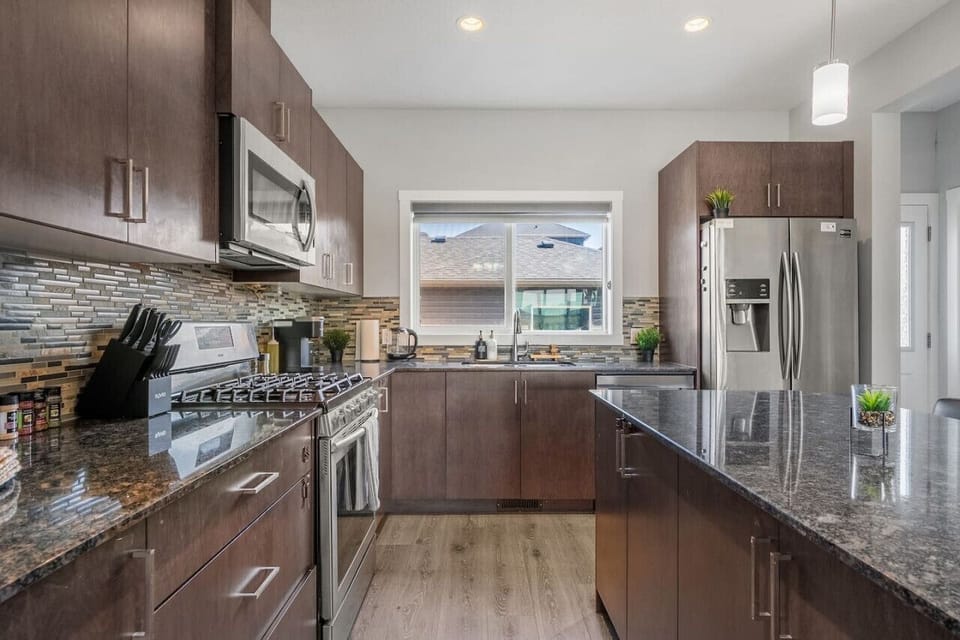 Our Warm Brown Toned Kitchen Featuring A Cozy Island And Spacious Fridge