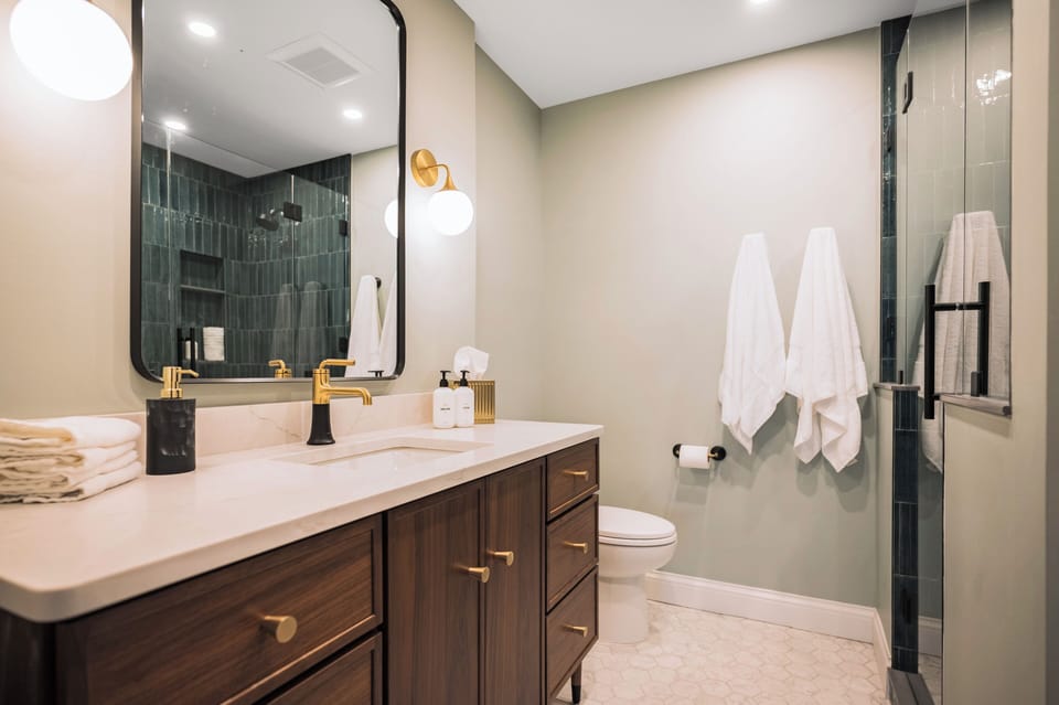 Relax in this modern, stylish bathroom featuring a sleek vanity and large mirror