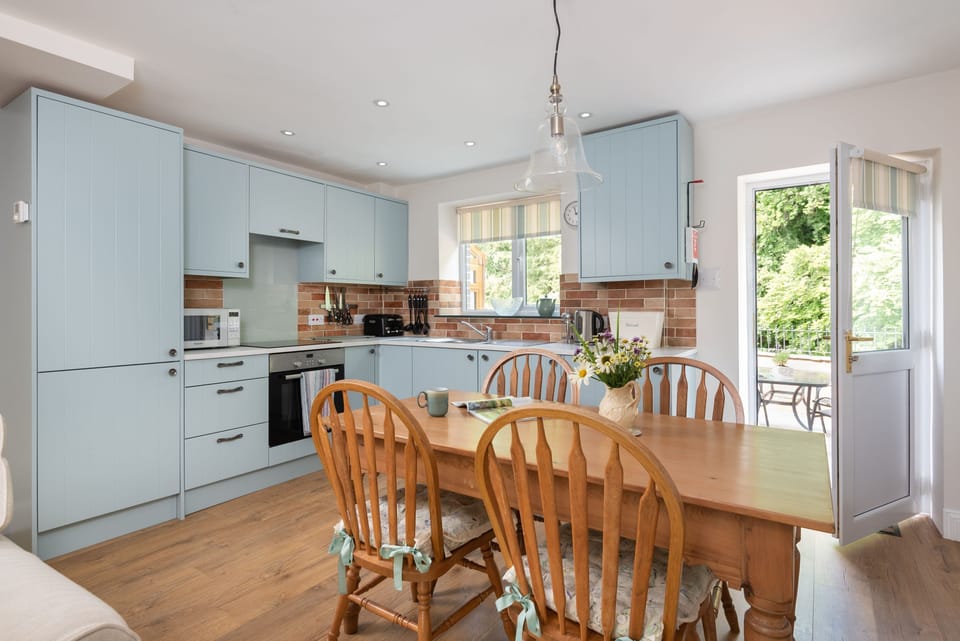 The kitchen and dining area is a functional and modern space with beautiful views over the River Greta