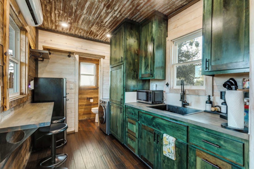 Step inside the cozy container, where compact design meets comfort. The space is thoughtfully arranged with clever storage solutions, a comfortable bed, and modern amenities, creating a warm and inviting atmosphere in a unique setting.