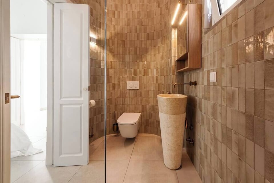 Spa-inspired bathroom with stone sink, warm tiles, and modern finishes