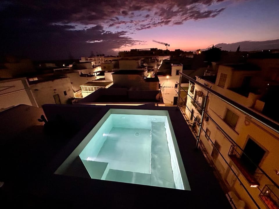 Rooftop plunge pool with sunset city views—your private escape