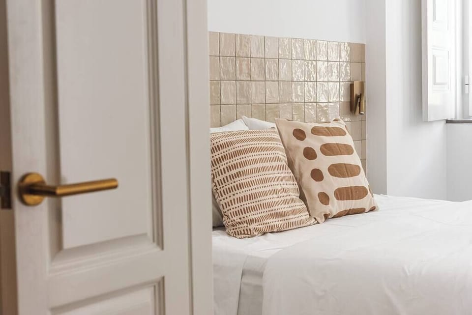 Bright minimalist bedroom with tiled headboard and cozy neutral accents