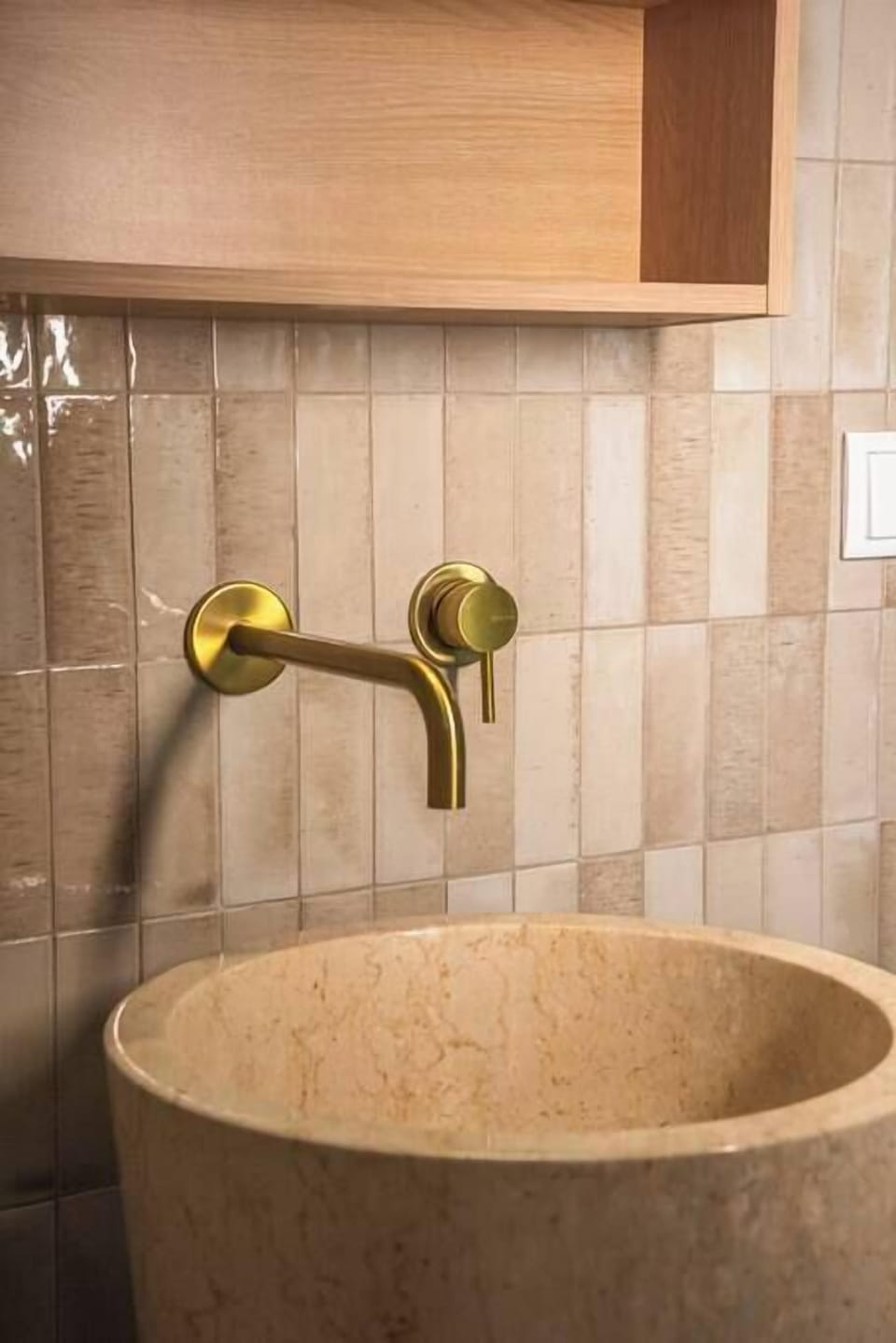 Spa-inspired bath with stone sink and elegant brass fixtures